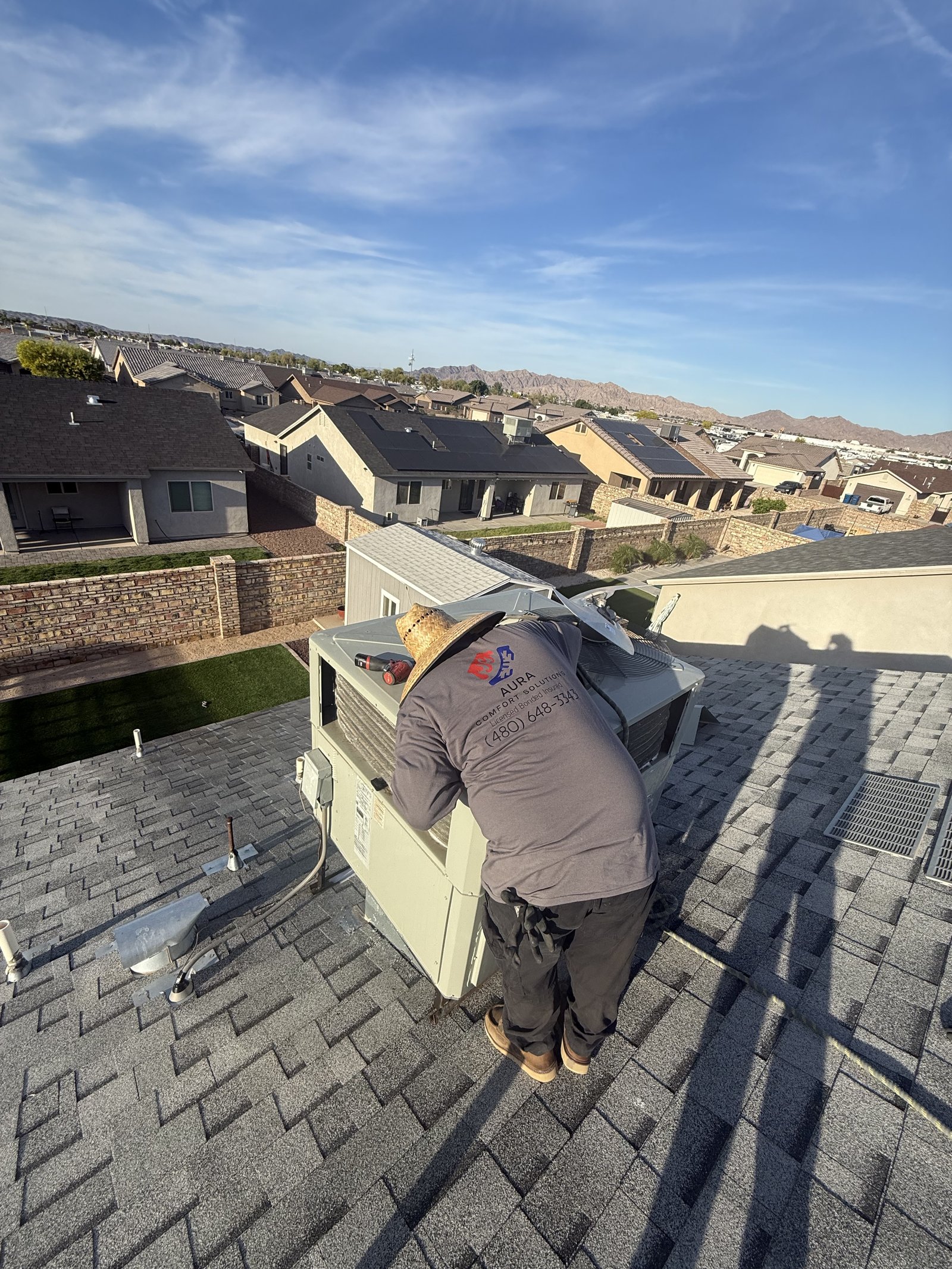 Aura tech servicing residential AC on roof